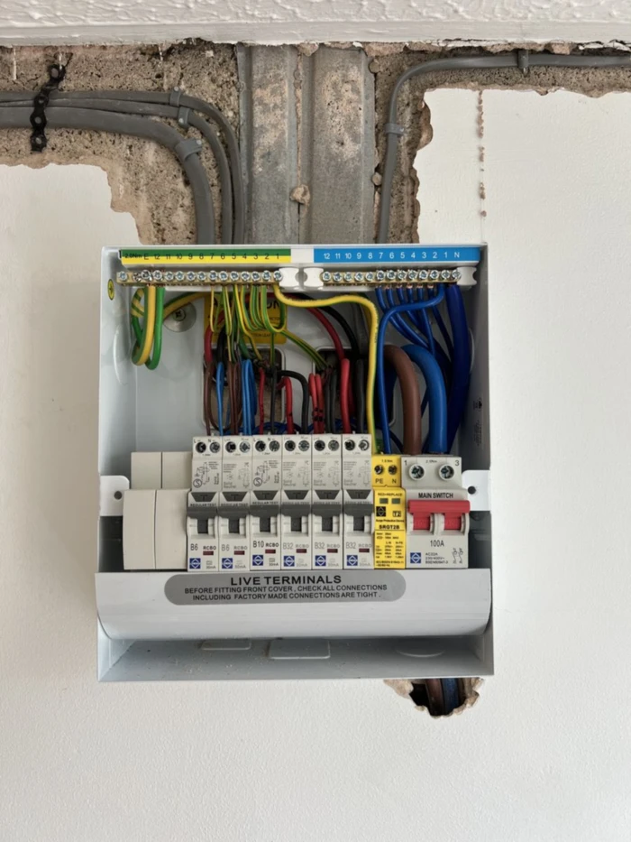 Replacement consumer unit fitted to a wall, wiring connected and labelled